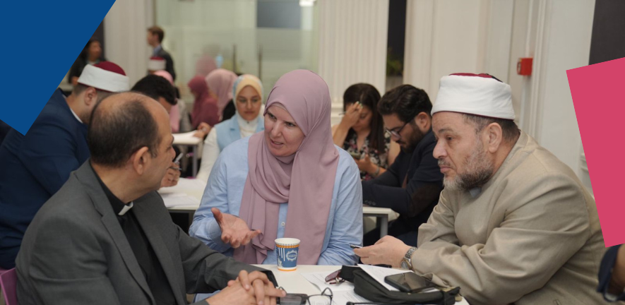 People in visibly religious clothing, sat at tables, speaking