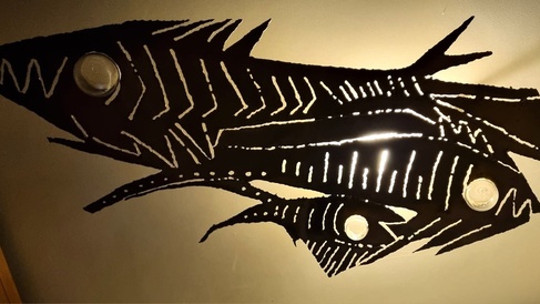 Three skeletal silhouettes of fish