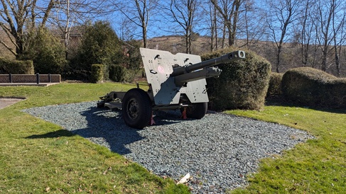 Winter sun shines on large military gun in fixed position