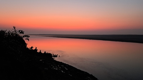 Red-pink light reflects on water. Dawn or dusk?