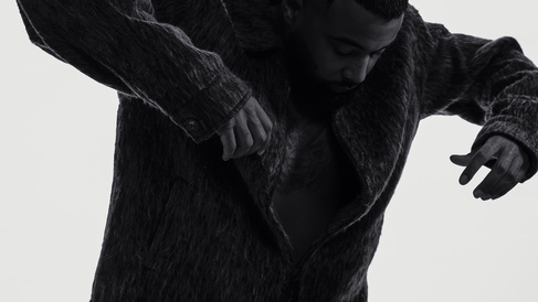 Three-quarter view of Mula B in silhouette, arms out, hands down, leaning forward  