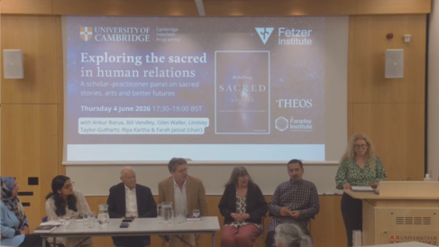 Esra at lectern gives welcome, panellists seated