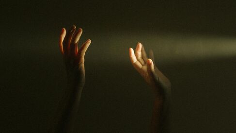 Hands raised up towards light