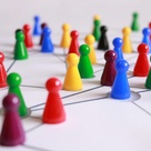 Coloured meeple placed on a black ink sketch to visualise a network 
