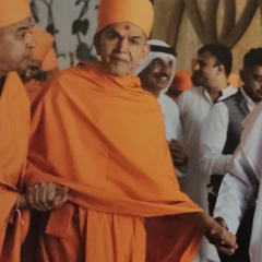 Two men in saffron robes, to their right a man in white dress--leading the central figure by the hand.