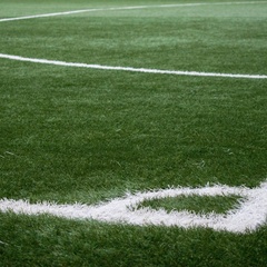 Painted white lines at the corner of a grass soccer pitch