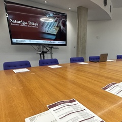 Room laid out pre-symposium, programmes, notepaper and digital presentation