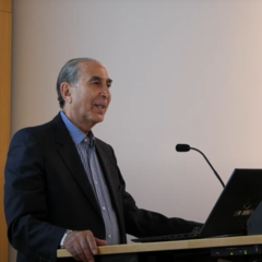 Sir David Khalili standing at lectern, mid-lecture