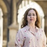 A profile photograph of Dr Vanessa Paloma Elbaz, with stone building behind