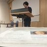 Safet stands at lectern, in foreground the conference programme is visible