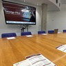 Room laid out pre-symposium, programmes, notepaper and digital presentation