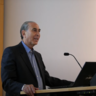 Sir David Khalili standing at lectern, mid-lecture