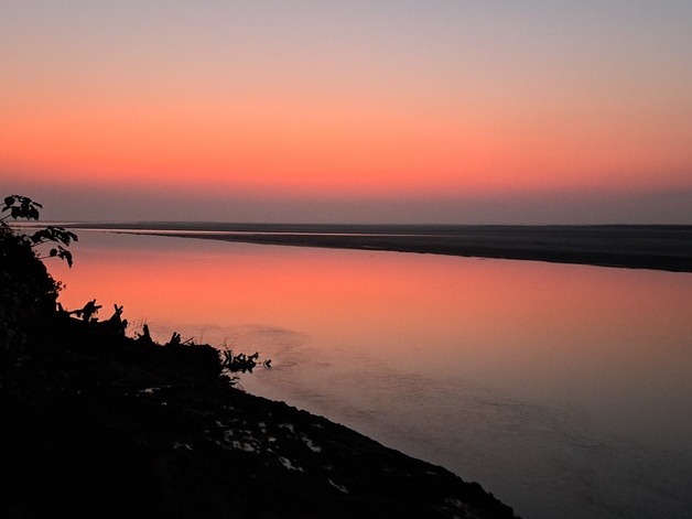 Red-pink light reflects on water. Dawn or dusk?