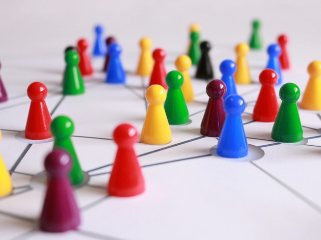 Coloured meeple placed on a black ink sketch to visualise a network 