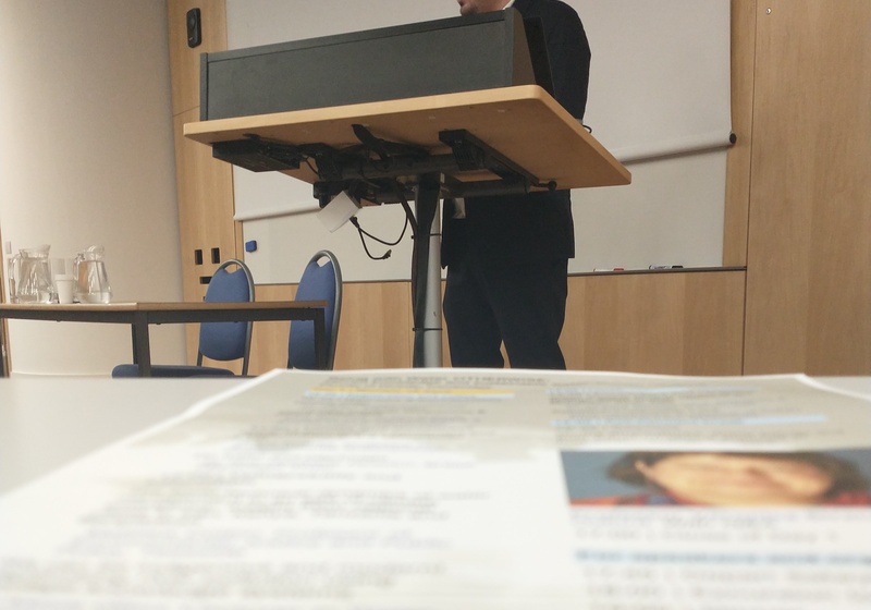 Safet stands at lectern, in foreground the conference programme is visible
