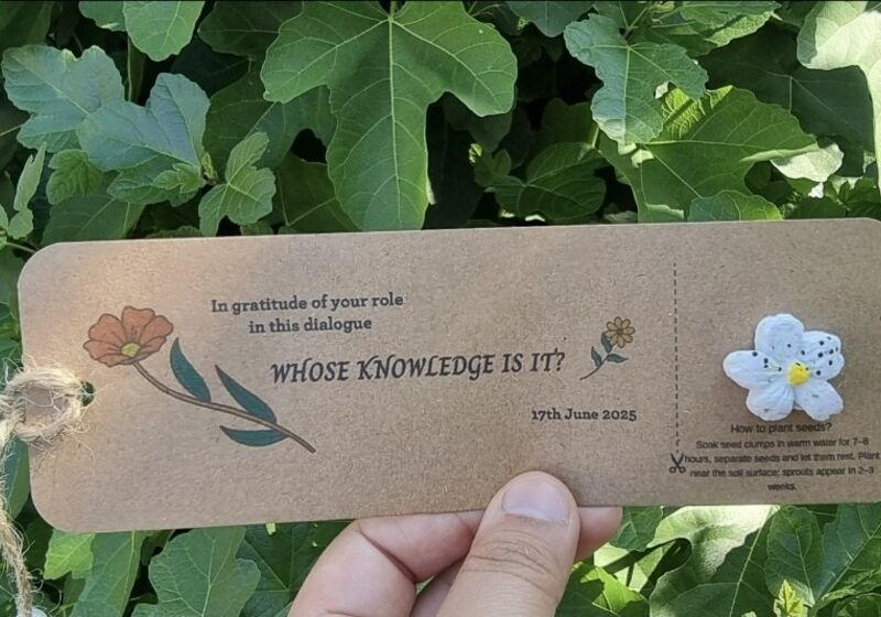A cardboard gift-tag with seeds to plant, message reading “In gratitude for your role in Whose knowledge is it?"