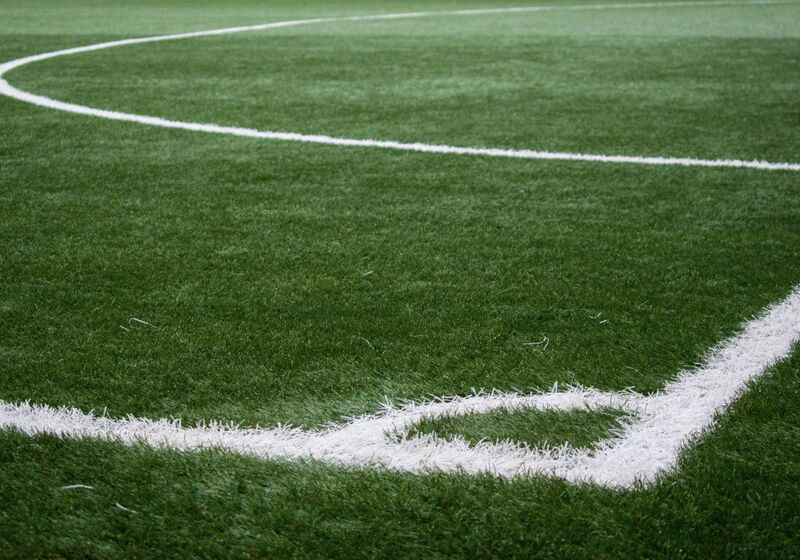 Painted white lines at the corner of a grass soccer pitch