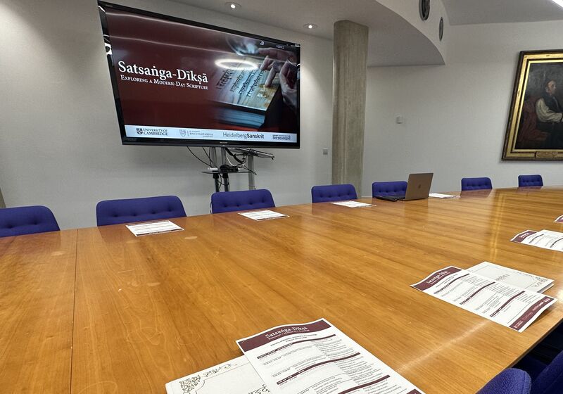 Room laid out pre-symposium, programmes, notepaper and digital presentation