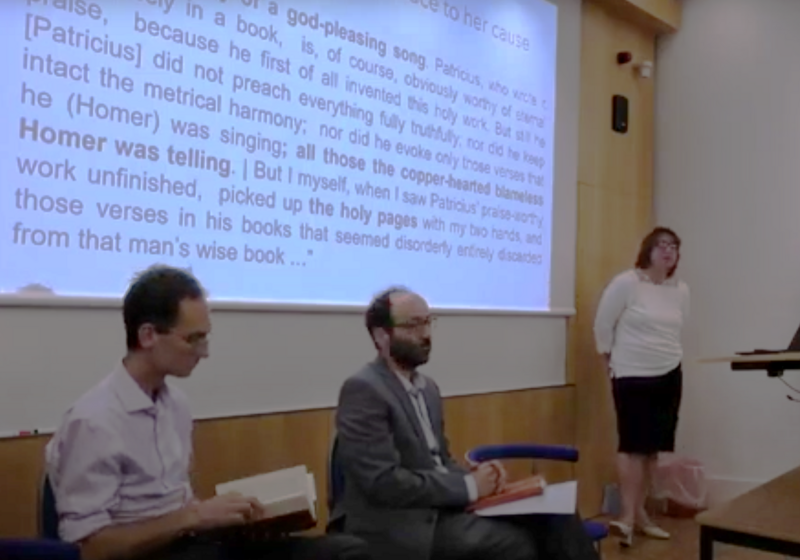 The three guests seated in front of a slide, Dr Lefteratou standing at lectern, Professor Van Kooten chairing questions. 