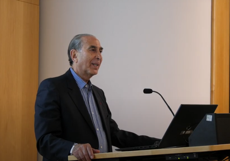 Sir David Khalili standing at lectern, mid-lecture