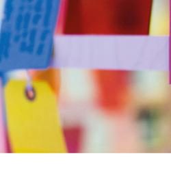 Colourful luggage tags hanging. Each has a handwritten message. Two pledges are legible: "I will, teach younger people about the Holocaust to make sure it is never forgotten. "I will continue to educate others and raise awareness about the Holocaust" 