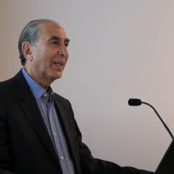 Sir David Khalili standing at lectern, mid-lecture