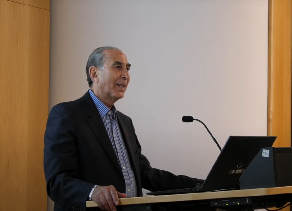 Professor Sir David Khalili delivering his lecture - May 2024 (Cambridge Interfaith Programme) Sir David Khalili standing at lectern, mid-lecture