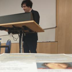 Safet stands at lectern, in foreground the conference programme is visible
