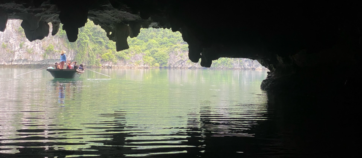 View from within a sea cave, looking outward toward a small boat