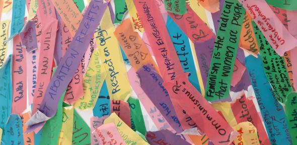 Strips of coloured paper with handwritten comments in German and English. Visible comments say "Kommunismus?" and "Feminism is the radical..."